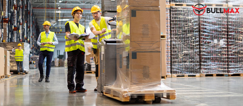 warehouse workers operating an electric pallet truck